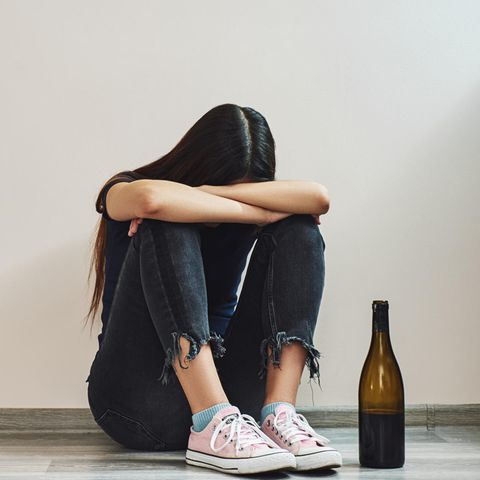 Mädchen neben Weinflasche
