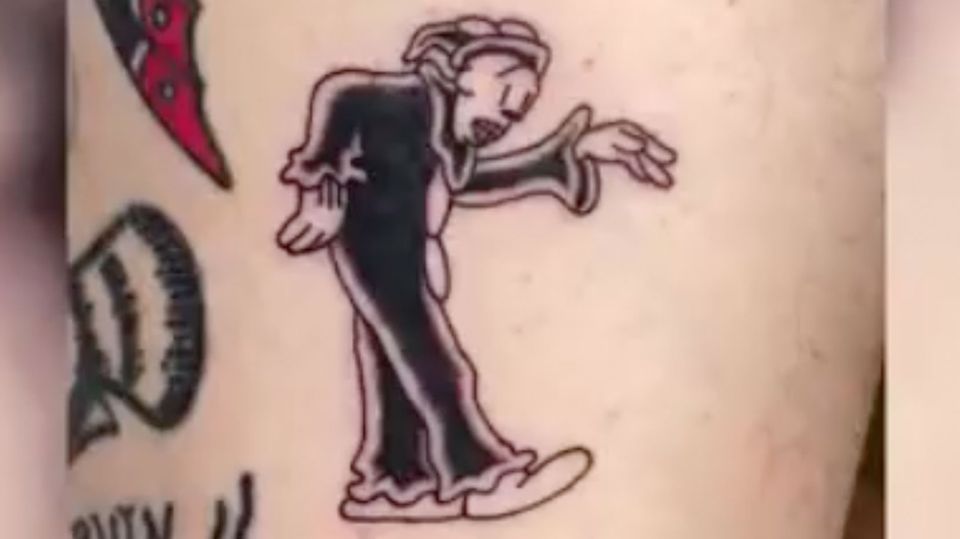 Ein frisches Tattoo auf Haut zeigt tanzenden Clown