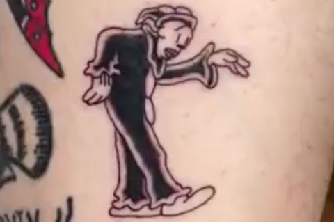 Ein frisches Tattoo auf Haut zeigt tanzenden Clown