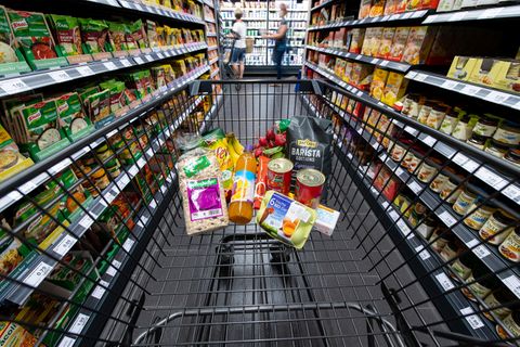Verschiedene Lebensmittel liegen in einem Supermarkt in einem Einkaufswagen