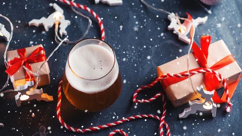 Bier-Adventskalender: Ein frisch gezapftes Bier steht zwischen Geschenken.