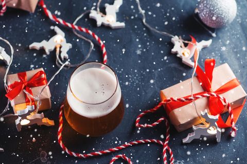 Bier-Adventskalender: Ein frisch gezapftes Bier steht zwischen Geschenken.