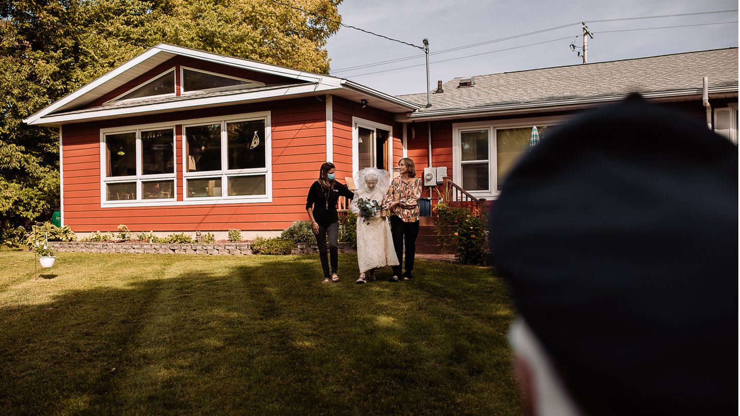 Die Braut Frankie King wird im Brautkleid in den Garten geführt. Ihr Mann Royce wartet mit verbundenen Augen auf sie