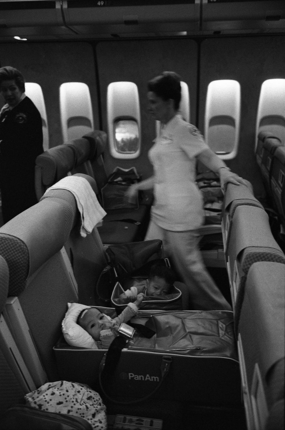 Am Ende des Vietnamkrieges: An Bord einer Boieng 747 von Pan Am: Krankenschwestern und vietnamesische Flüchtlingskinder auf einem Flug der Operation Babylift kurz vor der Ankunft auf dem San Francisco International Airport. An Bord einer Boieng 747 von Pan Am: Krankenschwestern und vietnamesische Flüchtlingskinder auf einem Flug der Operation Babylift kurz vor der Ankunft auf dem San Francisco International Airport.