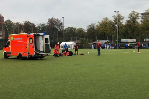 Krankenwagen auf Fußballfeld während Rettungshelfer Berkant Aydin behandeln