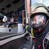 Alles neu nur eines hält sich tapfer: der Helm  Blick in ein Löschfahrzeug. Die Sitze links und rechts sind mit Haltevorrichtungen für das Atemgerät ausgestattet. Moderne Masken verfügen über ein Mikrofon und Funk. Die Kleidung ist aus Hightech-Material. Nur der Helm hat sich in vielen Wehren nicht verändert. Es ist immer noch die Form des alten Wehrmachtshelms M35 mit Nackenleder und phosphatierender Leuchtfarbe.  Farbige Streifen an der Helmseite zeigen den Rang des Trägers an. Ein roter Streifen: Gruppenführer, zwei rote Streifen: Zugführer, ein durchgehender roter Streifen: Kommandant. 