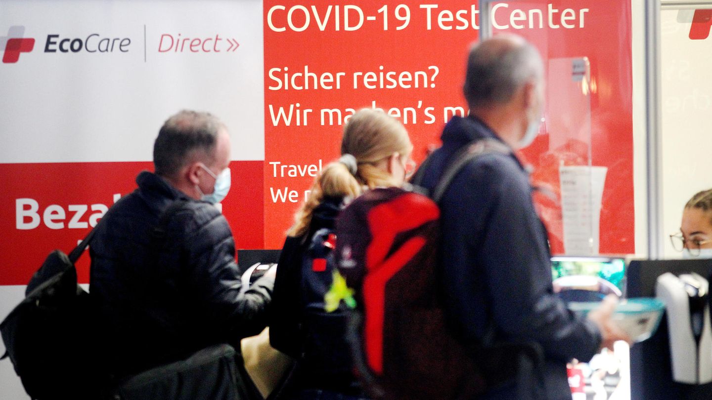 Reisende warten am Covid-19 Test Center auf dem Flughafen Düsseldorf auf ihre Testergebnisse