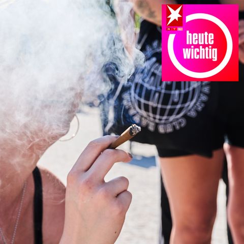 Das Gesicht einer jungen, weißen Frau verschwindet in einer Rauchwolke, während die Frau mit rechts einen Joint hält