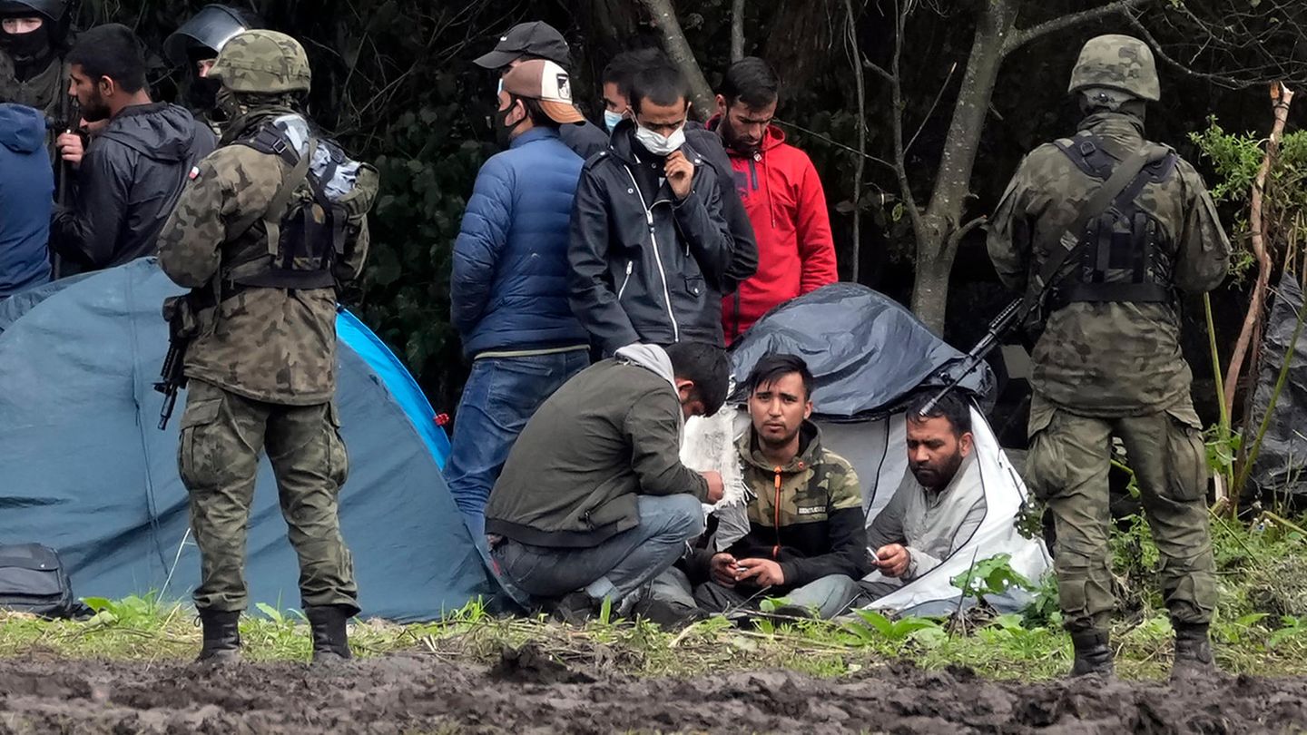 Polnische Sicherheitskräfte umringen Migranten, die an der Grenze zu Weißrussland festsitzen