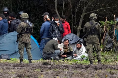Polnische Sicherheitskräfte umringen Migranten, die an der Grenze zu Weißrussland festsitzen
