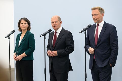 Annalena Baerbock, Olaf Scholz und Christian Lindner stehen vor Mikrofonen.