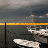 Ein Regenbogen erhebt sich nach starken Regenfällen über einem Acker.