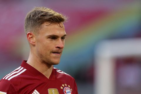 Ein junger weißer Mann mit blondem Seitenscheitel trägt das rot gemusterte Trikot des FC Bayern München
