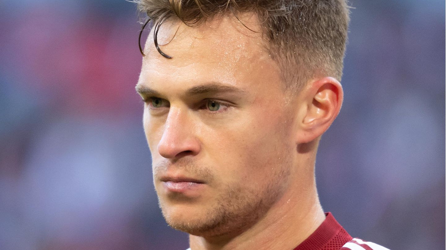 Ein junger weißer Mann mit dunkelblondem Seitenscheitel trägt ein rotes Trikot vom FC Bayern München und schaut ernst