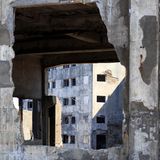 Durch ein Loch in der Wand blickt man auf ein weiteres Haus