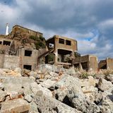 Ein weisser Leuchtturm steht hinter zertrümmerten Häusern