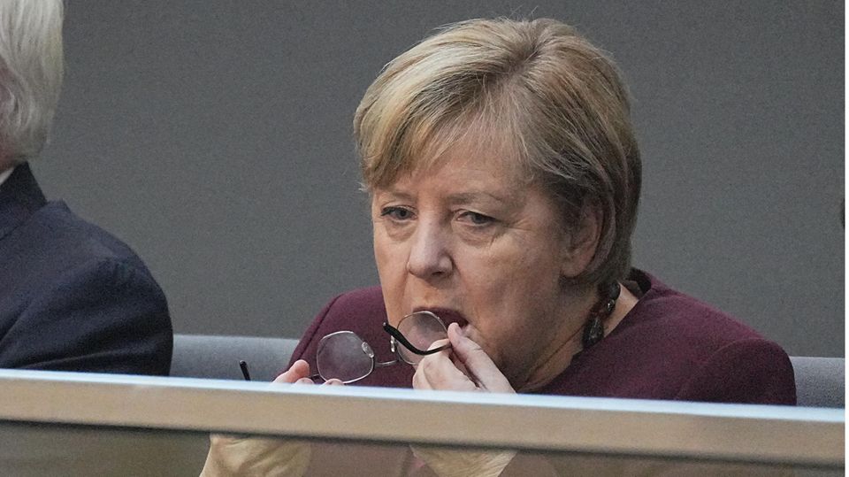 Merkel haucht auf die Gläser ihrer Brille