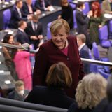 Merkel begrüßt freundlich die Sitznachbarn