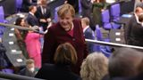 Merkel begrüßt freundlich die Sitznachbarn