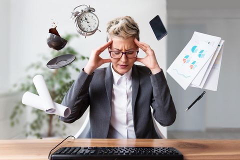 Bürofrau gestresst, umgeben von To Dos.