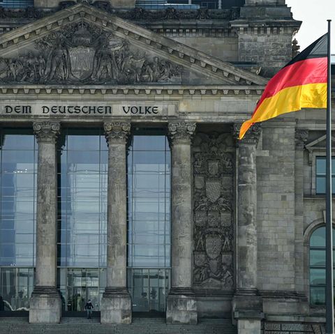 Vor dem Reichstagsgebäude weht eine Deutschland-Flagge an einem Flaggenmast