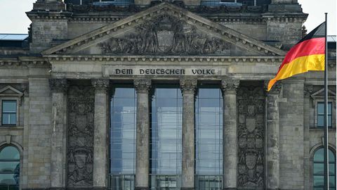 Vor dem Reichstagsgebäude weht eine Deutschland-Flagge an einem Flaggenmast