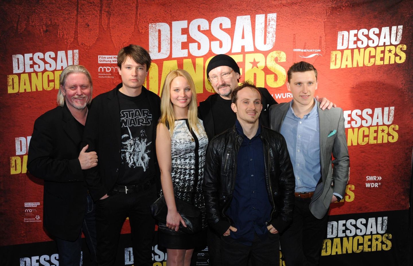 Zum Tod des Schauspielers: 2014 wirkte Arved Birnbaum (l.) an dem Film "Dessau Dancers" mit, der von der Entstehung der Breakdance-Bewegung in der DDR erzählt. Es war für ihn eine Reise in die eigene Vergangenheit: Birnbaum wurde 1962 in Forst in der Lausitz geboren. Zur Schauspielerei kam er erst spät: Zunächst absolvierte er eine Lehre als Elektriker und arbeitete dann als Außenmonteur für Industriewaschmaschinen im sozialistischen Ausland (Bulgarien, Rumänien und Ungarn). Ab 1989 konnte er dann seinen Traum verwirklichen: Er studierte an der Schauspielschule "Ernst Busch" in Rostock, 1993 schloss er seine Ausbildung ab. 2014 wirkte Arved Birnbaum (l.) an dem Film "Dessau Dancers" mit, der von der Entstehung der Breakdance-Bewegung in der DDR erzählt. Es war für ihn eine Reise in die eigene Vergangenheit: Birnbaum wurde 1962 in Forst in der Lausitz geboren. Zur Schauspielerei kam er erst spät: Zunächst absolvierte er eine Lehre als Elektriker und arbeitete dann als Außenmonteur für Industriewaschmaschinen im sozialistischen Ausland (Bulgarien, Rumänien und Ungarn). Ab 1989 konnte er dann seinen Traum verwirklichen: Er studierte an der Schauspielschule "Ernst Busch" in Rostock, 1993 schloss er seine Ausbildung ab.