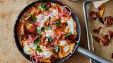 Süßkartoffel-Shakshuka mit Srirachabutter und gepickelten Zwiebeln      Zutaten:   1 kg Süßkartoffeln, sauber abgeschrubbt,1 kleine rote Zwiebel, in feine Ringe geschnitten (100 g), 2 EL Zitronensaft, 3 EL Olivenöl, 150 g gereifter Cheddar, grob gerieben, 3 Knoblauchzehen, zerdrückt, 1 TL Kreuzkümmelsamen, im Mörser grob zerstoßen, 8 Eier, 25 g Butter, ¾ EL Sriracha-Chilisauce, 2 EL Korianderblätter, Salz und schwarzer Pfeffer      Zubereitung:  1. Den Backofen auf 200 °C (Umluft) vorheizen. Die Süßkartoffeln rundherum acht- bis zehnmal mit einer Gabel einstechen, dann auf ein mit Backpapier ausgelegtes Blech geben. Im Ofen 45–50 Minuten backen, bis sie weich und durchgegart sind. Die Süßkartoffeln zum Abkühlen beiseitestellen, die Backofentemperatur auf 180 °C (Umluft) reduzieren.  2. Die Zwiebelringe in einer kleinen Schüssel mit 1 EL Zitronensaft sowie 1 Prise Salz verrühren; beiseitestellen.  3. Von den gegarten Süßkartoffeln die Schale abziehen. Das Fleisch in etwa 4 cm große Stücke zupfen und in einer großen Schüssel beiseitestellen. Die Kartoffelschalen zurück auf das Backblech geben und mit 1 EL Öl, ¼ TL Salz sowie 1 kräftigen Prise Pfeffer vermengen. Im Ofen 8 Minuten backen, bis sie schön gebräunt und knusprig sind. Zum Abkühlen beiseitestellen.  4. Das Süßkartoffelfleisch mit einer Gabel fein zerdrücken. Den Cheddar, den Knoblauch, den Kreuzkümmel, 1 EL Öl, den restlichen EL Zitronensaft, 1 TL Salz sowie 1 kräftige Prise Pfeffer untermengen.  5. In einer großen Pfanne, für die ein Deckel vorhanden ist, den restlichen EL Öl verteilen. Die Süßkartoffelmasse hineingeben und mit einem Löffel gleichmäßig verteilen. Bei mittlerer bis starker Hitze etwa 7 Minuten braten, bis die Unterseite etwas Farbe angenommen hat. Die Hitze auf mittlere Stufe reduzieren und mit einem Löffel acht Vertiefungen in die Süßkartoffelmasse drücken. In jede Vertiefung ein Ei aufschlagen, salzen und pfeffern. In der zugedeckten Pfanne 4–5 Minuten garen, bis das Eiweiß fest ist, die Eigelbe aber noch flüssig.  6. Während die Eier garen, Butter und Sriracha-Sauce in einem kleinen Topf bei mittlerer Temperatur erhitzen, bis die Butter geschmolzen ist, dabei unablässig mit einem Schneebesen schlagen, bis die Mischung emulgiert ist. Die Sriracha-Butter vom Herd nehmen, bevor sie Blasen wirft – sie darf nicht gerinnen.  7. Die Sriracha-Butter über die Eier gießen, 1 Handvoll von den knusprigen Schalenstücken, die Hälfte der gepickelten Zwiebelringe sowie die Korianderblätter hinzufügen. Sofort servieren und die Reste von knuspriger Kartoffelschale und eingelegter Zwiebel separat reichen.