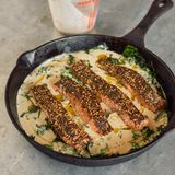 Lachs mit Za’atar und Tahin      Zutaten:  4 Lachsfilets (600 g) mit Haut, sorgfältig entgrätet, 2 EL Za’atar-Gewürzmischung, 2 TL Sumach, plus ½ TL mehr zum Bestreuen, 60 ml Olivenöl, 250 g junge Spinatblätter, 90 g Tahin (Sesammus), 3 Knoblauchzehen, zerdrückt, 3½ EL Zitronensaft, 1½ EL grob gehackte Korianderblätter, Salz und schwarzer Pfeffer      Zubereitung:  1. Den Backofen auf 220 °C (Umluft) vorheizen.  2. Die Fischfilets trocken tupfen, dann mit Salz und Pfeffer würzen. Za’atar und Sumach in einer kleinen Schüssel verrühren; die Oberseite der Filets damit bestreuen.  3. In einer großen ofenfesten Pfanne 1 EL Öl bei mittlerer bis hoher Temperatur erhitzen. Den Spinat mit je 1 Prise Salz und Pfeffer hineingeben und 2–3 Minuten zusammenfallen lassen.  4. Die Lachsfilets mit der Haut nach unten auf den Spinat betten und mit 2 EL Öl beträufeln. Im Ofen 5 Minuten backen.  5. Inzwischen das Tahin in einer kleinen Schüssel mit Knoblauch, 2½ EL Zitronensaft, 1 kräftigen Prise Salz und 100 ml Wasser verrühren; die Sauce sollte glatt und recht flüssig sein.  6. Nach Ablauf der Garzeit die Pfanne aus dem Ofen nehmen und die Tahinsauce um den Lachs herumgießen (aber auf keinen Fall über den Fisch). Den Fisch weitere 5 Minuten backen, bis er durchgegart ist und die Sauce brodelt. Vor dem Servieren mit restlichem Zitronensaft und Öl (jeweils 1 EL) beträufeln und mit Korianderblättern und Sumach bestreuen.