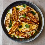 Gegrillte Zucchini mit Joghurtsauce und Safranbutter      Zutaten:  30 g Butter, ¼ TL Safranfäden, grob zerstoßen, 4 kleine Zucchini, vom Stielansatz befreit und längs halbiert (600 g), 2½ EL Olivenöl, 1 TL Speisestärke, 300 g griechischer Joghurt, 2 Knoblauchzehen, zerdrückt, ½ TL getrocknete Minze, ¾ TL Korianderkörner, geröstet und im Mörser grob zerstoßen, 1½ EL Minzeblätter, ½ Zitrone, Salz und schwarzer Pfeffer      Zubereitung:  1. Den Backofengrill vorheizen.  2. Die Butter mit dem Safran in einen kleinen Topf geben. Bei mittlerer Hitze zerlassen, dann vom Herd nehmen, beiseitestellen und ziehen lassen.  3. Die Zucchini auf ein mit Back- papier ausgelegtes Blech geben. Mit 2 EL Öl, . TL Salz und 1 kräftigen Prise Pfeffer durchheben. Anschließend mit der Schnittfläche nach oben 15–20 Minuten grillen, bis sie gut gebräunt und weich sind.  4. In den letzten 10 Minuten der Garzeit für die Sauce die Speisestärke in einer großen Schüssel mit 3 EL Wasser glatt rühren, dann Joghurt, Knoblauch, getrocknete Minze, den restlichen ½ EL Öl sowie ½ TL Salz dazugeben und alles verquirlen. Die Mischung in eine große antihaftbeschichtete Pfanne gießen und bei mittlerer Temperatur 10 Minuten erhitzen. Unablässig rühren, bis die Sauce warm ist und leicht eindickt. Sie darf nicht aufkochen, sonst gerinnt sie.  5. Die warme Joghurtsauce in eine Schale gießen, die Zucchini mit der Schnittfläche nach oben darauf anrichten. Das Ganze mit der Safranbutter beträufeln, dann mit Koriander und Minzeblättern bestreuen. Die Zitronenhälfte darüber auspressen und das Gericht sofort servieren.