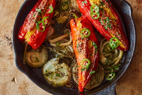 Paprikaschoten mit Maisfüllung und gepickelten Jalapeños      Zutaten:  1 grüne Jalapeño-Chilischote, in feine Ringe geschnitten (15 g), 2 EL Apfelessig, 1 TL Zucker, 250 g TK-Maiskörner, aufgetaut, 100 g Schlagsahne, 50 g Instant-Polenta, 3 Knoblauchzehen, zerdrückt, 1 Ei, 105 ml Olivenöl, 75 g schnittfester Mozzarella, grob gerieben, 75 g gereifter Cheddar, grob gerieben, 4 rote Spitzpaprikaschoten, 2 Zwiebeln, jeweils in 5 Scheiben à 1 cm geschnitten, 5 g Thymianzweige, 10 g Koriandergrün, fein gehackt, Salz und schwarzer Pfeffer      Zubereitung:  1. Den Backofen auf 180 °C (Umluft) vorheizen.  2. Die Chiliringe in einer kleinen Schüssel mit Essig und Zucker verrühren. Beiseitestellen.  3. Den Mais mit Sahne, Polenta, zwei Dritteln des Knoblauchs, dem Ei, 1 EL Öl, ¾ TL Salz und 1 sehr kräftigen Prise Pfeffer im Mixer in wenigen kurzen Intervallen sehr grob pürieren. In eine Schüssel geben und beide Käsesorten unterrühren.  4. Die Paprikaschoten mit einem kleinen scharfen Messer längs einschneiden, ohne die Enden zu durchtrennen; die Stiele intakt lassen. Mit den Fingern die Kerne vorsichtig entfernen. Die Schoten mit der Maismischung füllen.  5. In einer großen gusseisernen Pfanne 1 EL Öl verteilen und mit Zwiebelscheiben und Thymian bedecken; leicht salzen und pfeffern. Die Paprikaschoten mit der Öffnung nach oben auf die Zwiebeln setzen und mit 1 EL Öl beträufeln. Mit etwas Salz und Pfeffer bestreuen, dann 200 ml Wasser in die Pfanne (nicht auf die Paprikaschoten) gießen. 30 Minuten backen, dann die Ofentemperatur auf 200 °C (Umluft) erhöhen und die Schoten weitere 20 Minuten backen, bis alles weich und schön gebräunt ist.  6. Inzwischen die restlichen 4 EL Öl in einer kleinen Schüssel mit Koriandergrün, 1 Msp. Salz und etwas Pfeffer verrühren.  7. Die Paprikaschoten mit dem Koriander-Öl beträufeln, mit den gepickelten Jalapeños bestreuen und warm servieren.