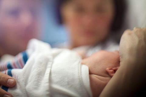 Ein Baby in den Armen seiner Mutter.
