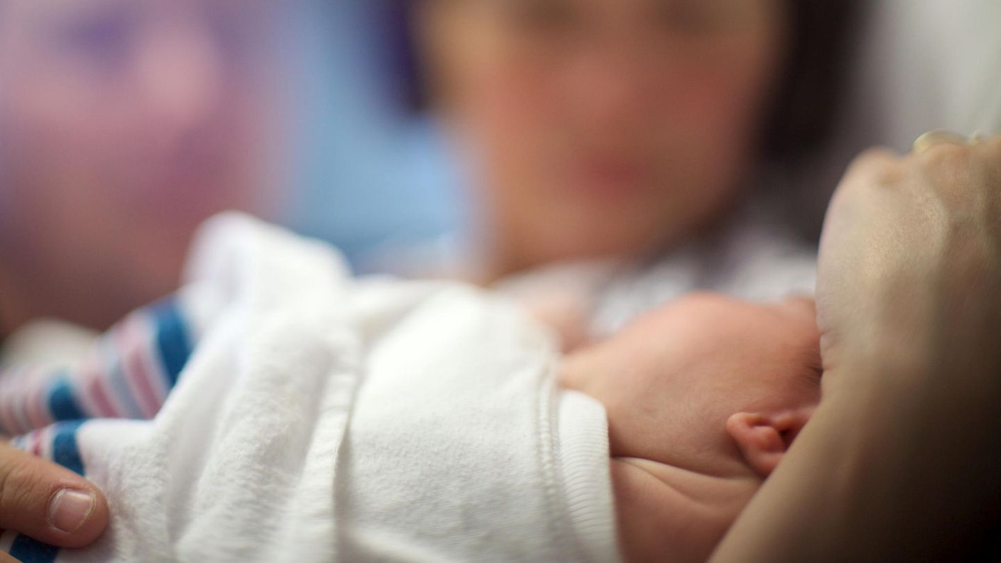 Ein Baby in den Armen seiner Mutter.