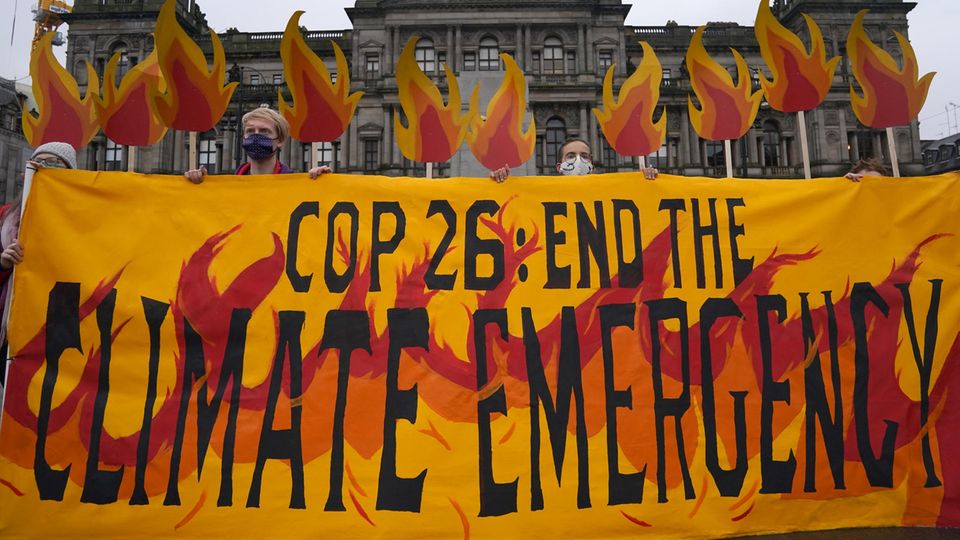 Klimaaktivisten mit einem Banner auf dem George Square in Glasgow