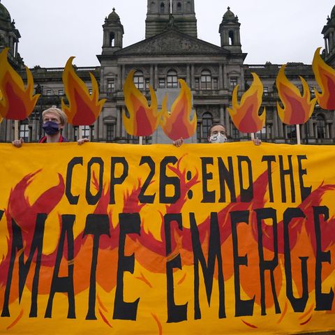 Klimaaktivisten mit einem Banner auf dem George Square in Glasgow