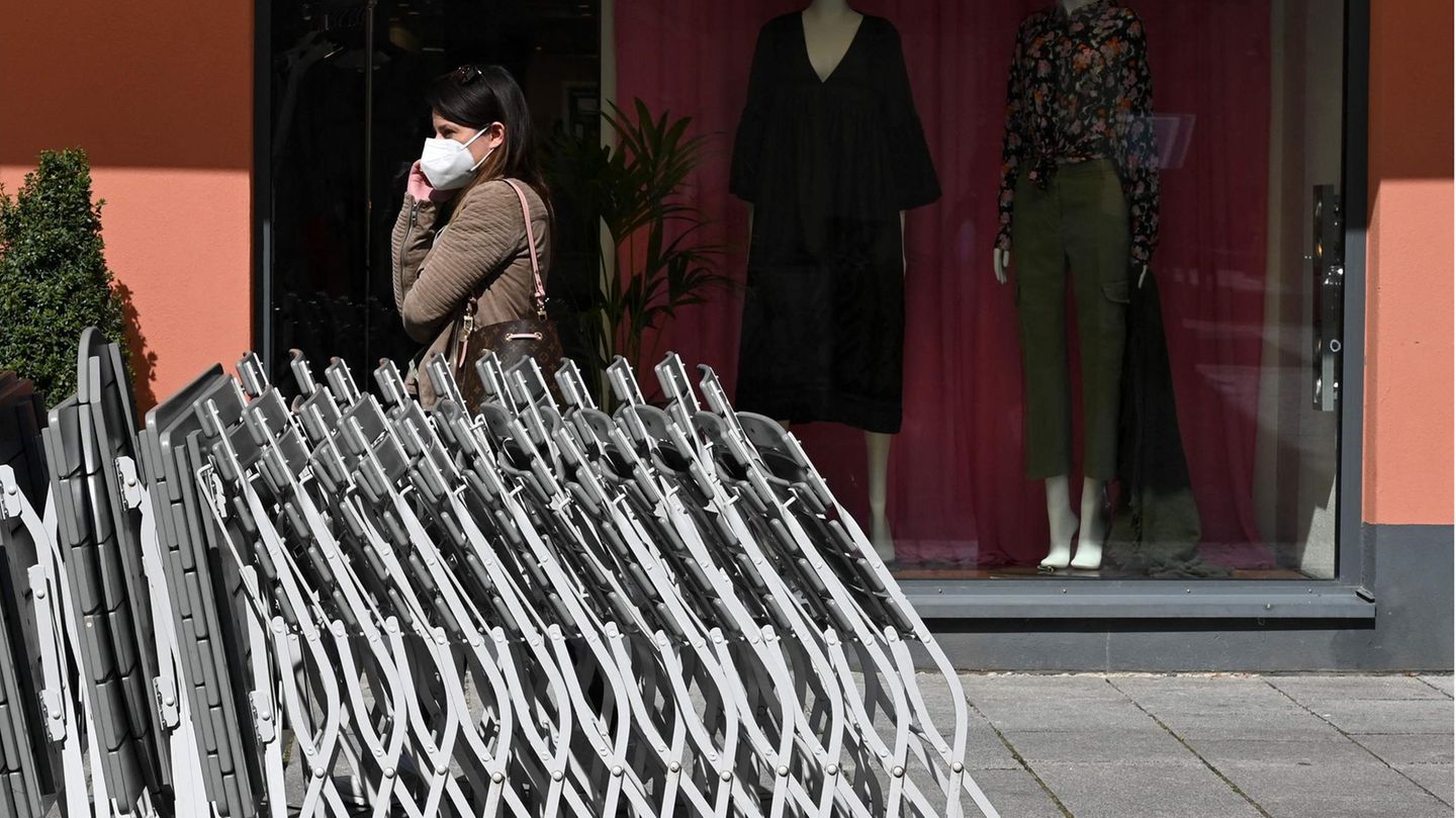 Eine Frau trägt eine FFP2-Maske vor einem Geschäft in Rosenheim (Bayern)