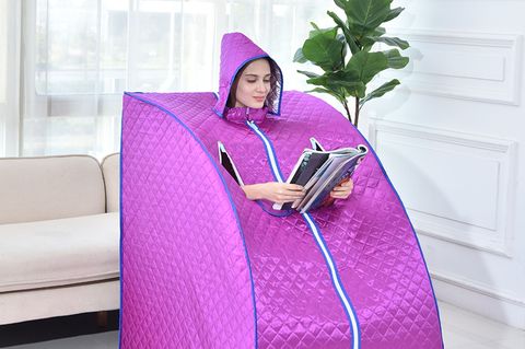 Mobile Sauna: Junge Frau sitzt in einer mobilen Saunakabine