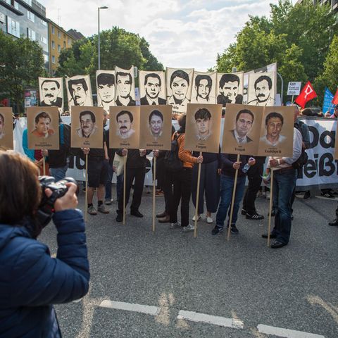 Am Tag des Urteils am 11.07.2018 halten Demonstranten Portraits der Ermordeten vor dem Gericht in München