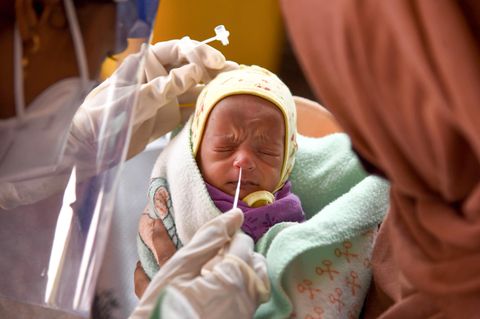 Nasenabstrich bei einem Baby in Mumbai, Indien: Lohnt eine Immunität durch "Primärinfektion"?