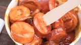 Für die Wurst von Sebastian Lege kommt zu dem Brät noch eine ordentliche Ladung Eiswürfel. Dadurch kommt mehr Volumen in die Wurst, aber auch die Konsistenz wird cremiger. Die fertige Mischung landet im Darm, so dass Würste entstehen. Diese werden bei moderater Temperatur gegart. Dadurch werden die Eiweiße schnittfest und die Hülle platzt nicht auf. Um noch ein paar Grillstreifen auf die Wurst zu zaubern, schiebt Lege seine Würstchen unter den Kontaktgrill.