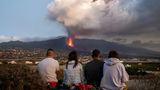 Mehrere Menschen sehen sich den Vulkanausbruch aus sicherer Entfernung an. Der Ausbruch lockt auch viele Touristen auf die Kanareninsel.