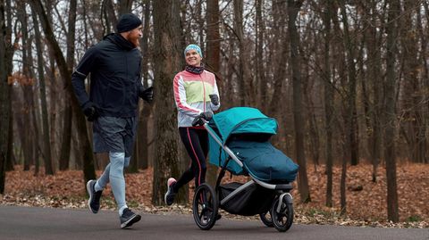 Winterfußsack: Pärchen läuft mit Babyjogger