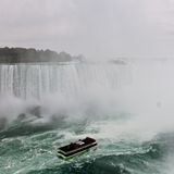 So kennen viele die Niagarafälle: der große, u-förmige Wasserfall, der in die Tiefe rauscht. Davor ist ein Boot.