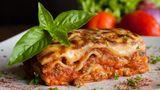 Lasagne  Lasagne gilt als eines der ältesten Pastagerichte: Bereits in der römischen Antike wurden "Lagana", also dünne Nudelblätter, verspeist. Die Römer nutzten in der Antike eine im Mittelmeerraum weit verbreitete Technik: Es wurden flache Teigblätter hergestellt, die dann zu Streifen weiterverarbeitet und gekocht werden. Diese Blätter wurden lagana genannt, worauf sich das heutige lasagna zurückführen lässt. Die Zubereitung aus Teigfladen geht lückenlos bis in die Antike zurück. In einem Traktat des Apicius (4. Jahrhundert n. Chr.) sind zwei derartige Rezepte beschrieben.    Hierzulande kriegen wir das Gericht aus der Antike als "Lasagne al forno" in den Restaurants serivert. Lasagne besteht aus Schichten von Nudelplatten, ist traditionell mit Fleisch gefüllt, mit einer sämigen Bechamél-Sauce umgeben und mit Parmesan überbacken.
