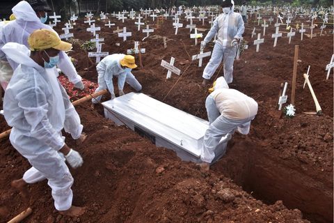 Totengräber bestatten auf einem Friedhof in Bekasi, Indonesien, einen Mann. der an Covid-19 gestorben ist