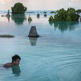 Junge schwimmt durch überflutete Teile von Kiribati