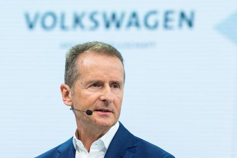 VW-Chef Herbert Diess spricht in ein Mikro, darüber der Schriftzug "Volkswagen"