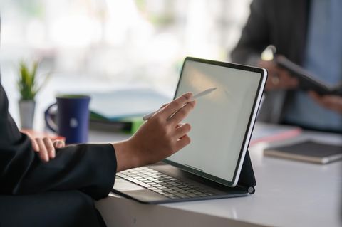 iPad Air vs. iPad Pro: Eine Frau sitzt am Schreibtisch und zeichnet mit dem Apple Pencil auf einem iPad.