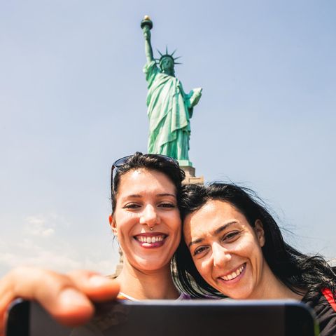 Zwei junge Frauen mache ein Selfie vor der Freiheitsstatue in den USA
