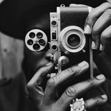 Ein Mann schießt ein Foto mit einer analogen Kamera.